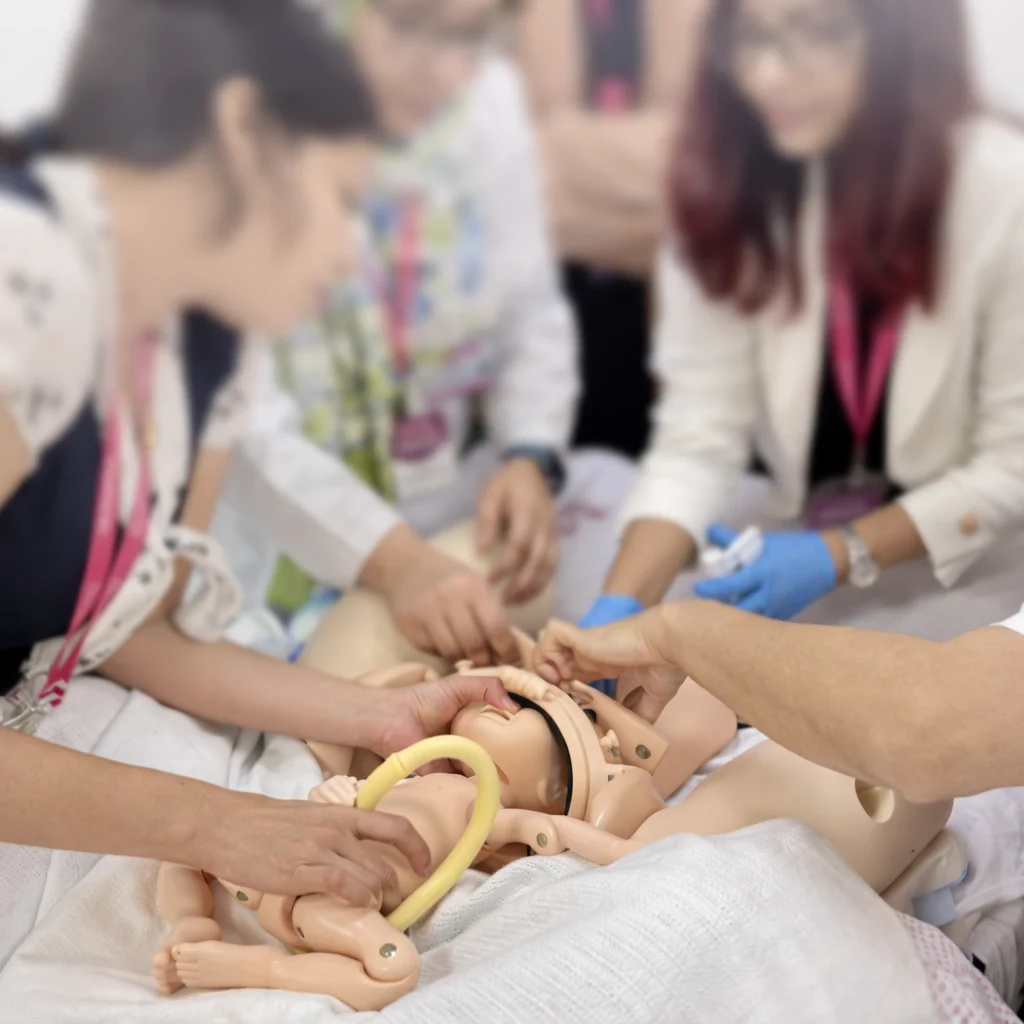 Practicing medical procedure on infant mannequin